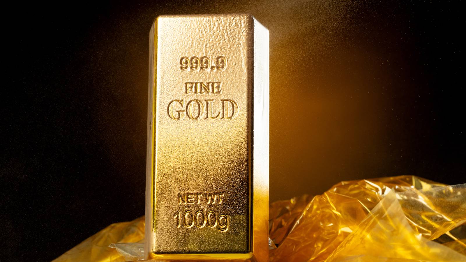 Auf der einen Waagschale ein Goldbarren, auf der anderen ein fragezeichenförmiger Schatten, als Symbol für Risiko